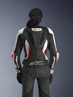 Vue arrière de la combinaison en cuir 2 pièces Alpinestars Stella GP-R7 en noir, blanc et rouge fluo, avec bosse aérodynamique arborant le logo GP-R7, panneaux en cuir perforé, zones extensibles en accordéon et logo Tech-Air® Ready sur le bas du dos.