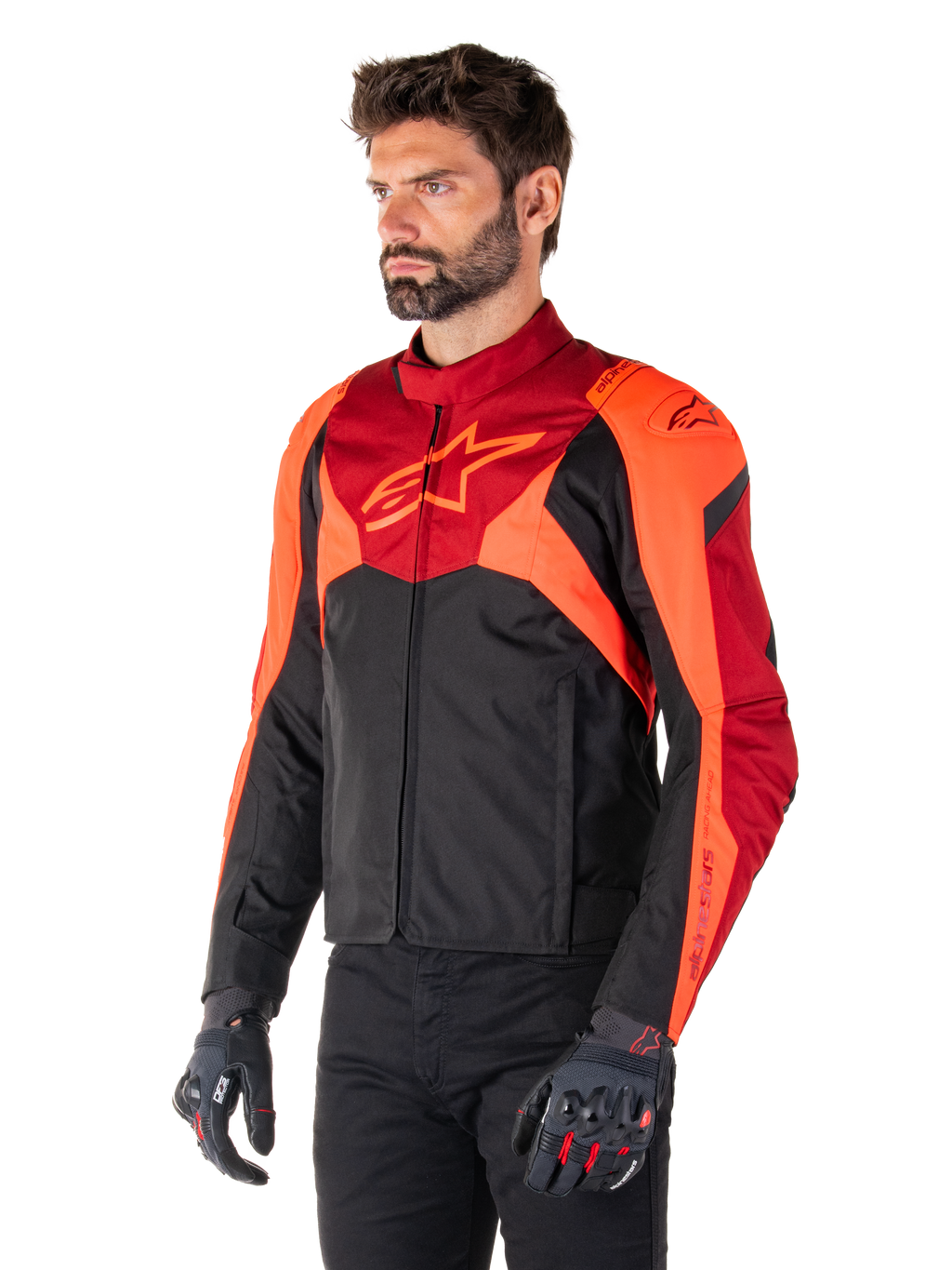 Alpinestars T-Jaws V4 Waterproof Jacket, Black Red Fluo and Dark Red, worn by a male model with black pants and motorcycle gloves, aggressive sport silhouette with Alpinestars logo on the chest, three-quarter view