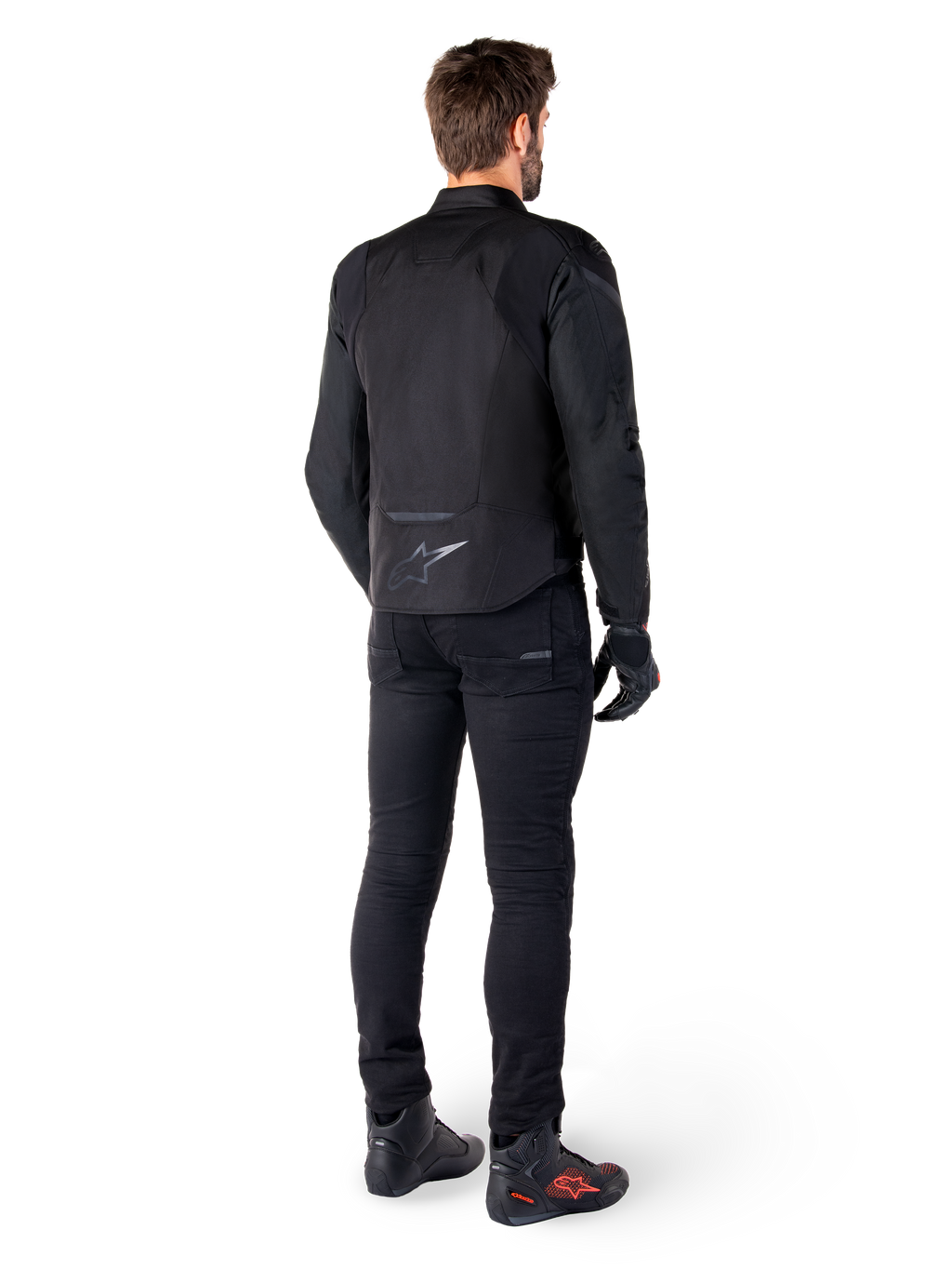 Alpinestars T-Jaws V4 Waterproof Jacket, Black, rear view on model wearing black riding pants and boots, showcasing the sport textile construction and Alpinestars logo on the lower back.
