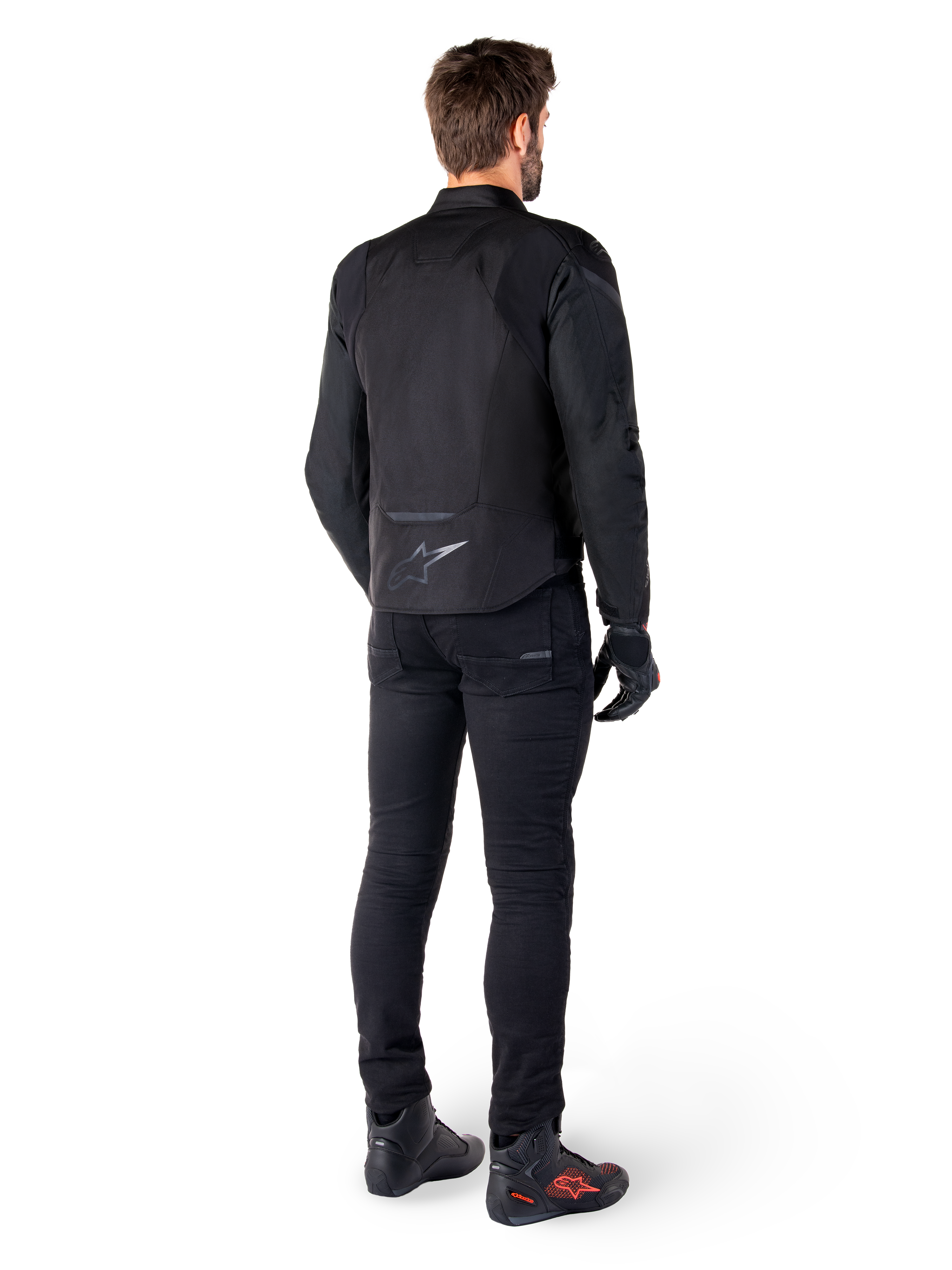 Alpinestars T-Jaws V4 Waterproof Jacket, Black, rear view on model wearing black riding pants and boots, showcasing the sport textile construction and Alpinestars logo on the lower back.