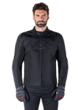 Alpinestars T-SPS V2 Waterproof Jacket, veste de moto textile noire, portée par un motard avec des gants noirs et rouges, dotée d'un col montant, d'une fermeture éclair frontale et d'un logo discret sur la poitrine, protection imperméable pour la conduite sportive et urbaine