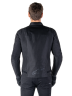 Veste Alpinestars T-SPS V2 Waterproof, noir, vue de dos montrant la silhouette à coupe sport, logo Alpinestars réfléchissant sur le bas du dos, et dos allongé pour une couverture supplémentaire en position de conduite.