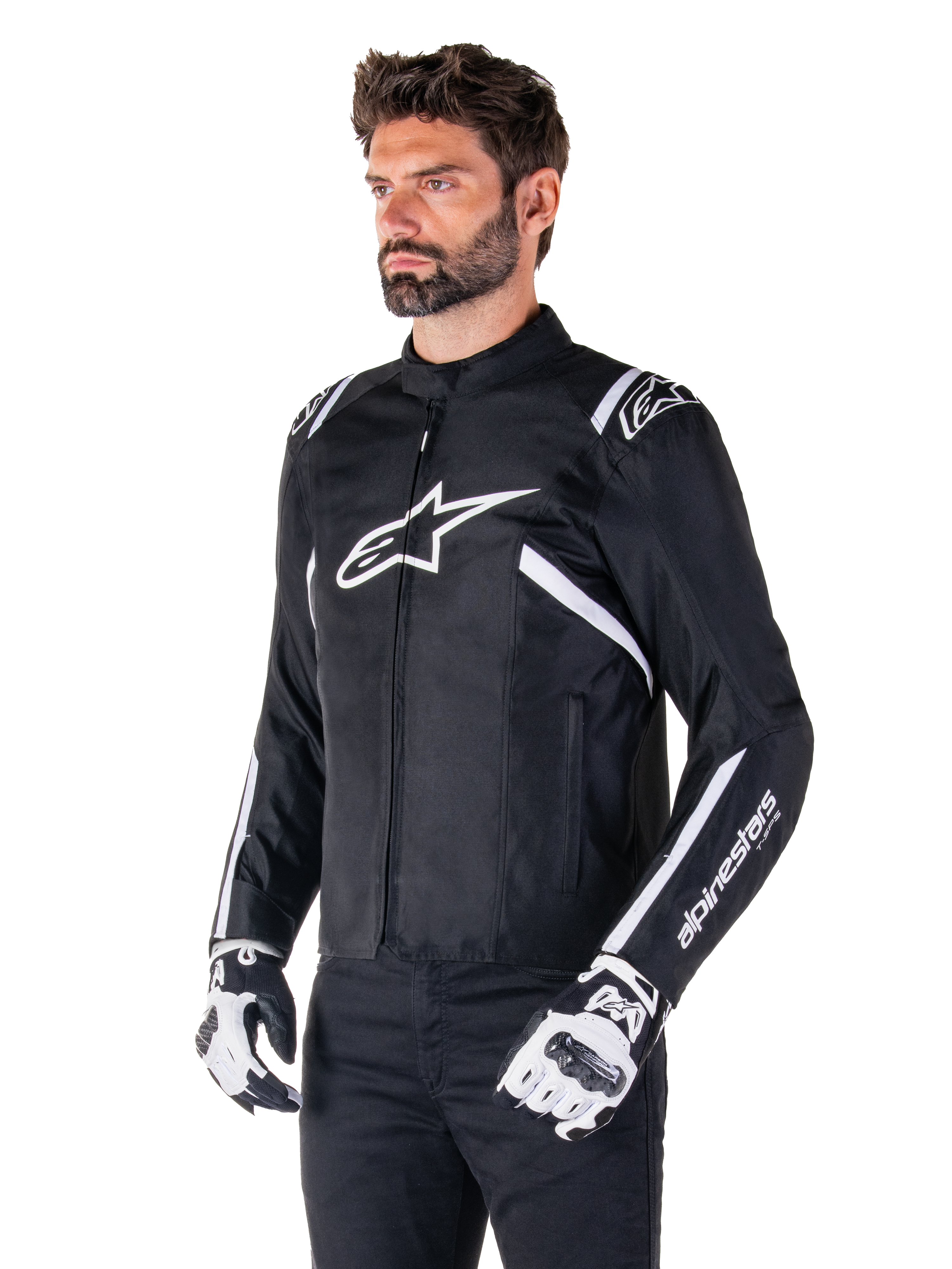Veste imperméable Alpinestars T-SPS V2, noir et blanc, portée par un mannequin homme avec des gants de moto assortis, veste textile à coupe sport avec logos Alpinestars blancs sur la poitrine et les épaules, marquage « alpinestars T-SPS » sur la manche, équipement de moto élégant inspiré de la course