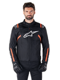 Veste imperméable Alpinestars T-SPS V2, noir, blanc et rouge fluo, portée par un mannequin homme avec des gants de moto noirs, avec un grand logo Alpinestars blanc sur la poitrine et des accents orange vif sur les épaules et les manches.