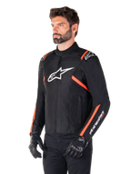 Veste imperméable Alpinestars T-SPS V2, noir, blanc et rouge fluo, portée par un mannequin homme avec des gants et un pantalon noirs, arborant un logo Alpinestars blanc sur la poitrine et des accents rouge fluo sur les épaules et les manches, design textile sportif