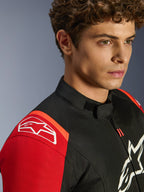 Veste imperméable Alpinestars T-SPS V2, veste de moto en textile, noir, rouge et rouge fluo, gros plan du mannequin portant la veste, avec logos Alpinestars blancs sur l'épaule et la poitrine, col à profil bas et coupe sport athlétique.