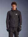 Veste imperméable Alpinestars Aeroshell, noire, veste de moto urbaine, design à capuche avec fermeture éclair frontale, logos blancs sur la poitrine et les manches, portée avec un pantalon et des gants noirs assortis