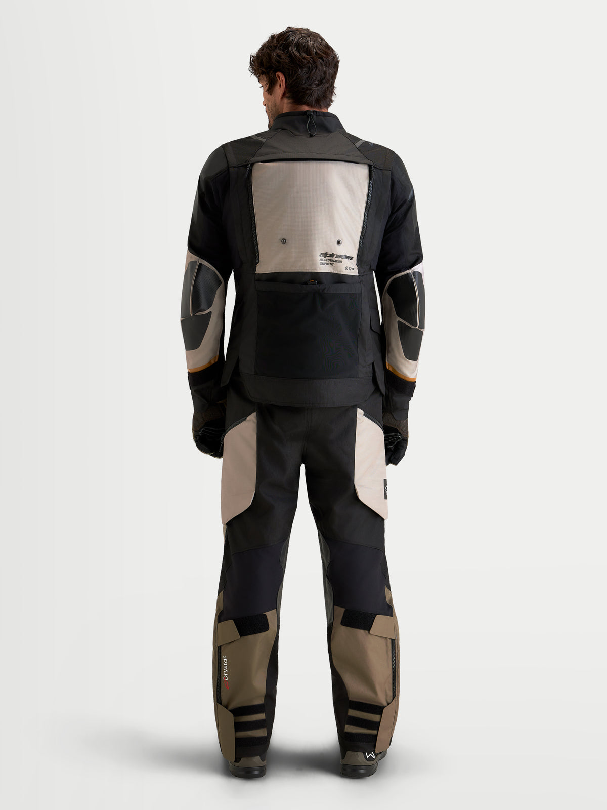 Alpinestars Harok V2 Drystar® tenue complète, veste et pantalon de moto adventure pour homme en noir et khaki, vue de dos sur un modèle portant un équipement de protection imperméable en textile avec détails renforcés