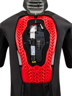 Système d'airbag Alpinestars Tech-Air 5 Plasma, vue interne montrant la cartouche de rechange noire installée et l'unité de contrôle électronique, intégrée dans une protection dorsale Nucleon Plasma rouge vif à l'intérieur d'un gilet de protection noir