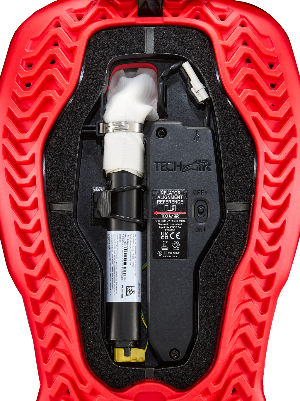 Alpinestars Tech-Air® 5 Plasma, cartouche de remplacement pour airbag, accessoire pour système airbag, rouge et noir, vue interne détaillée montrant la cartouche d'argon blanche avec collier argenté, l'unité de contrôle électronique avec interrupteur ON/OFF et la coque extérieure rouge à motifs ondulés.