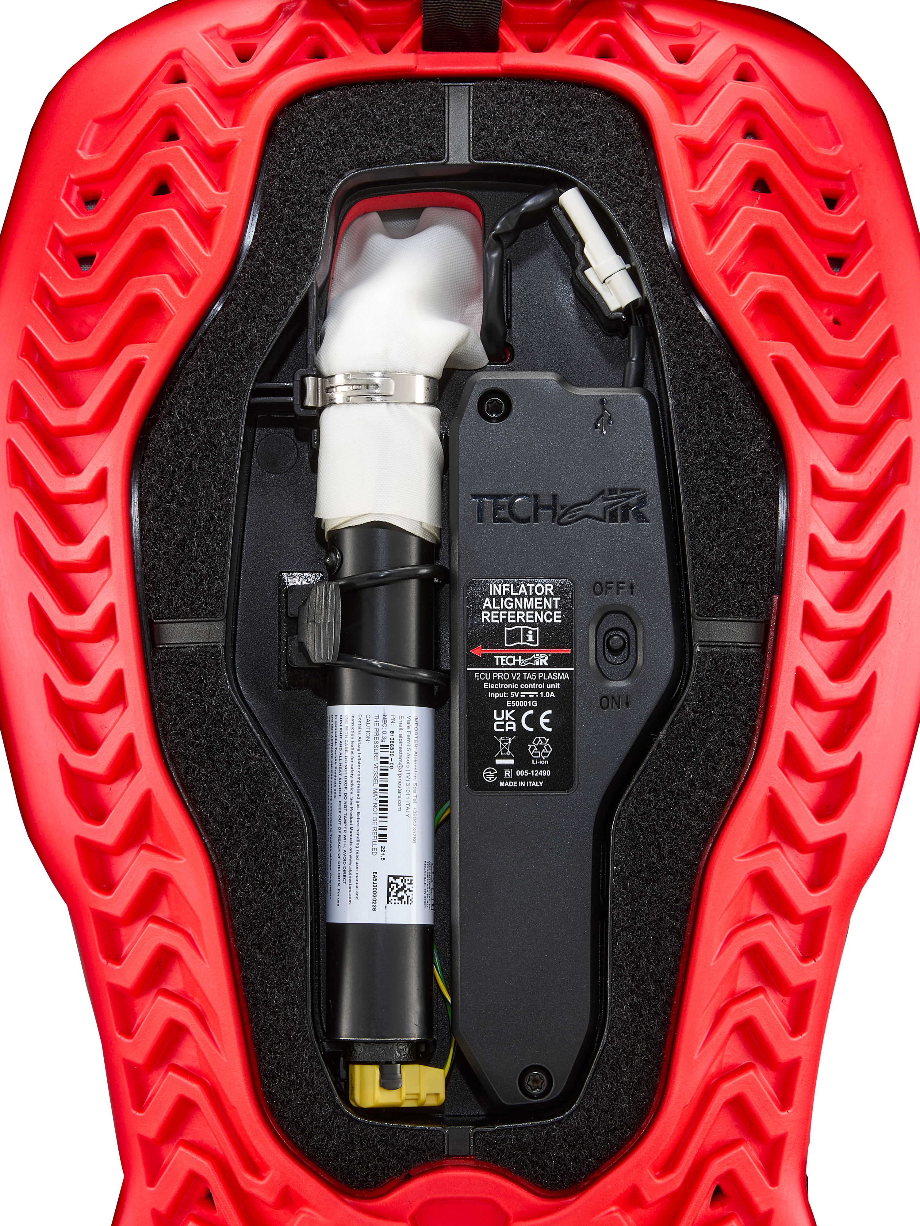 Alpinestars Tech-Air® 5 Plasma, cartouche de remplacement pour airbag, accessoire pour système airbag, rouge et noir, vue interne détaillée montrant la cartouche d'argon blanche avec collier argenté, l'unité de contrôle électronique avec interrupteur ON/OFF et la coque extérieure rouge à motifs ondulés.
