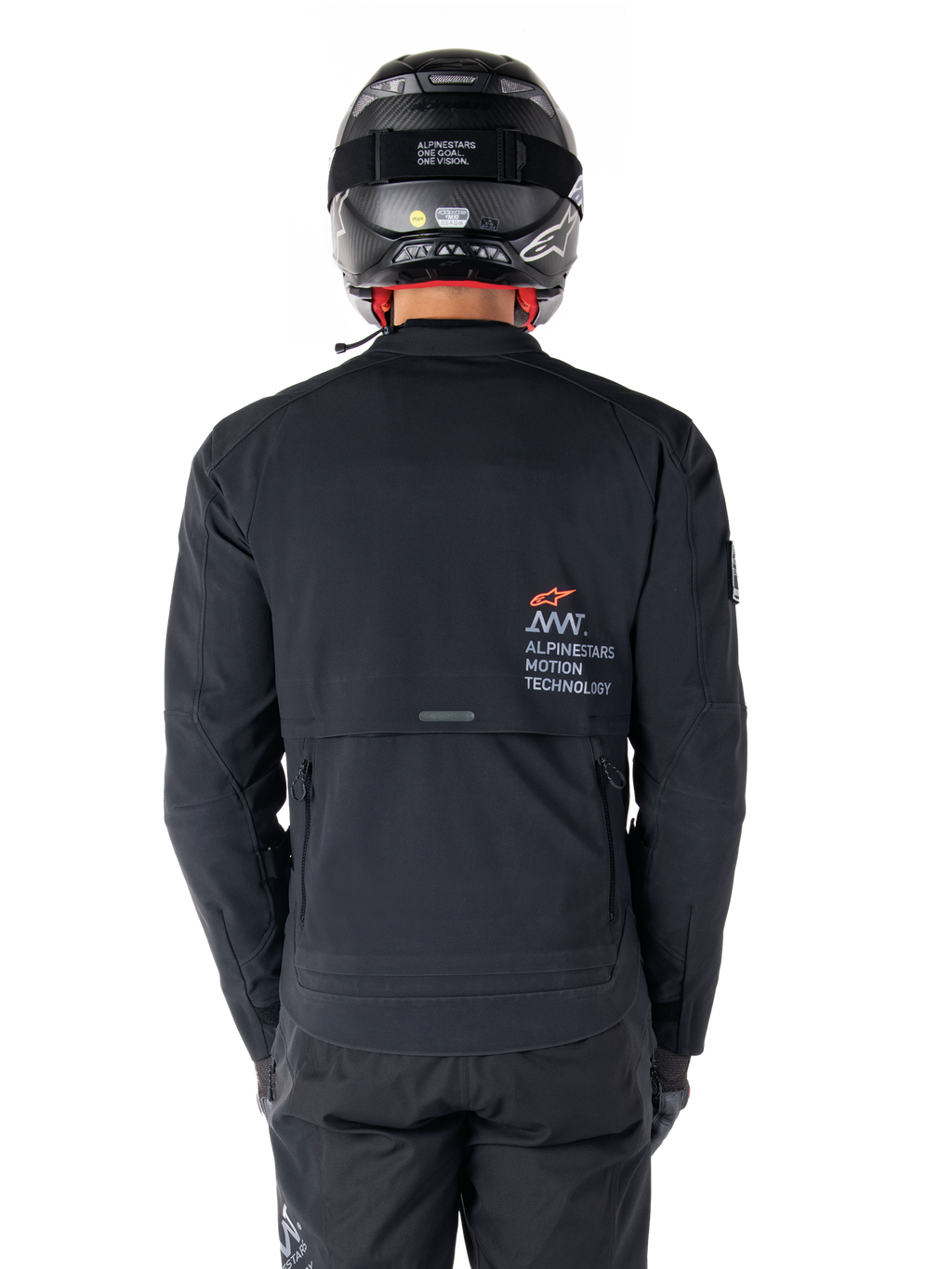 Veste Alpinestars AMT-8 Stretch Drystar® XF, vue arrière, noire, portée avec un casque et un pantalon noirs, avec le marquage Alpinestars Motion Technology au dos, design adventure touring en matériau stretch ergonomique