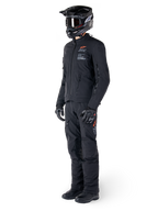Veste Alpinestars AMT-8 Stretch Drystar® XF, veste de moto aventure, noire, portée avec pantalon, casque et gants assortis, avec marquage Alpinestars Motion Technology et accents orange, construction stretch durable pour le pilotage aventure