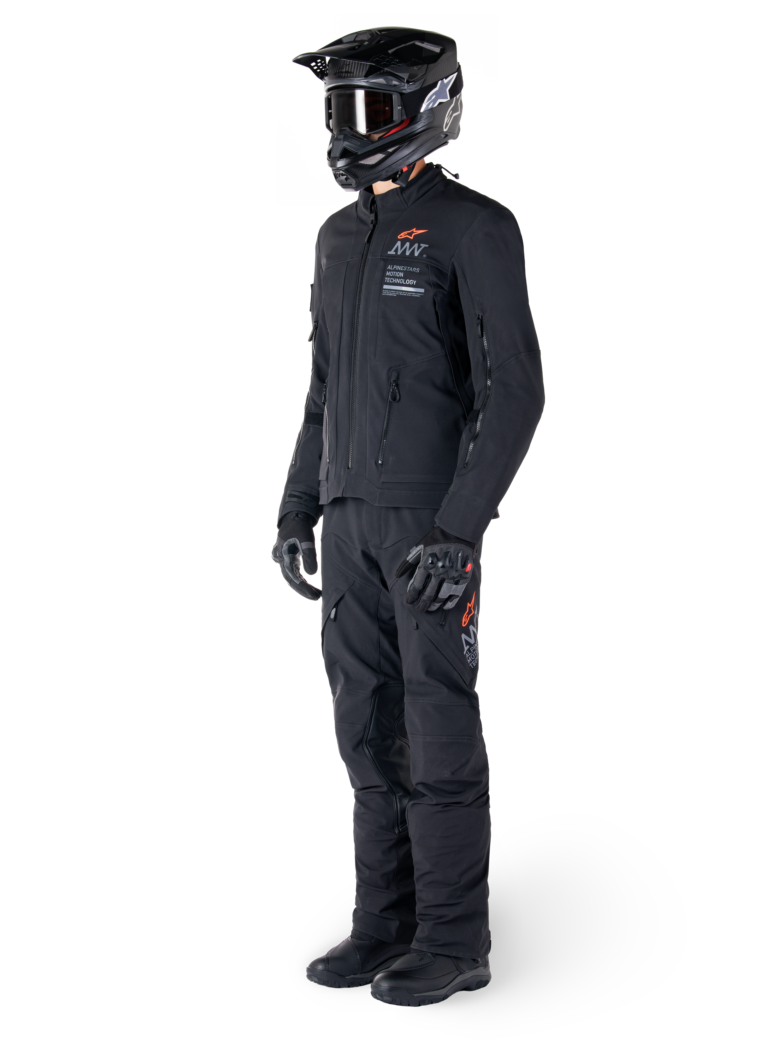 Veste Alpinestars AMT-8 Stretch Drystar® XF, veste de moto aventure, noire, portée avec pantalon, casque et gants assortis, avec marquage Alpinestars Motion Technology et accents orange, construction stretch durable pour le pilotage aventure