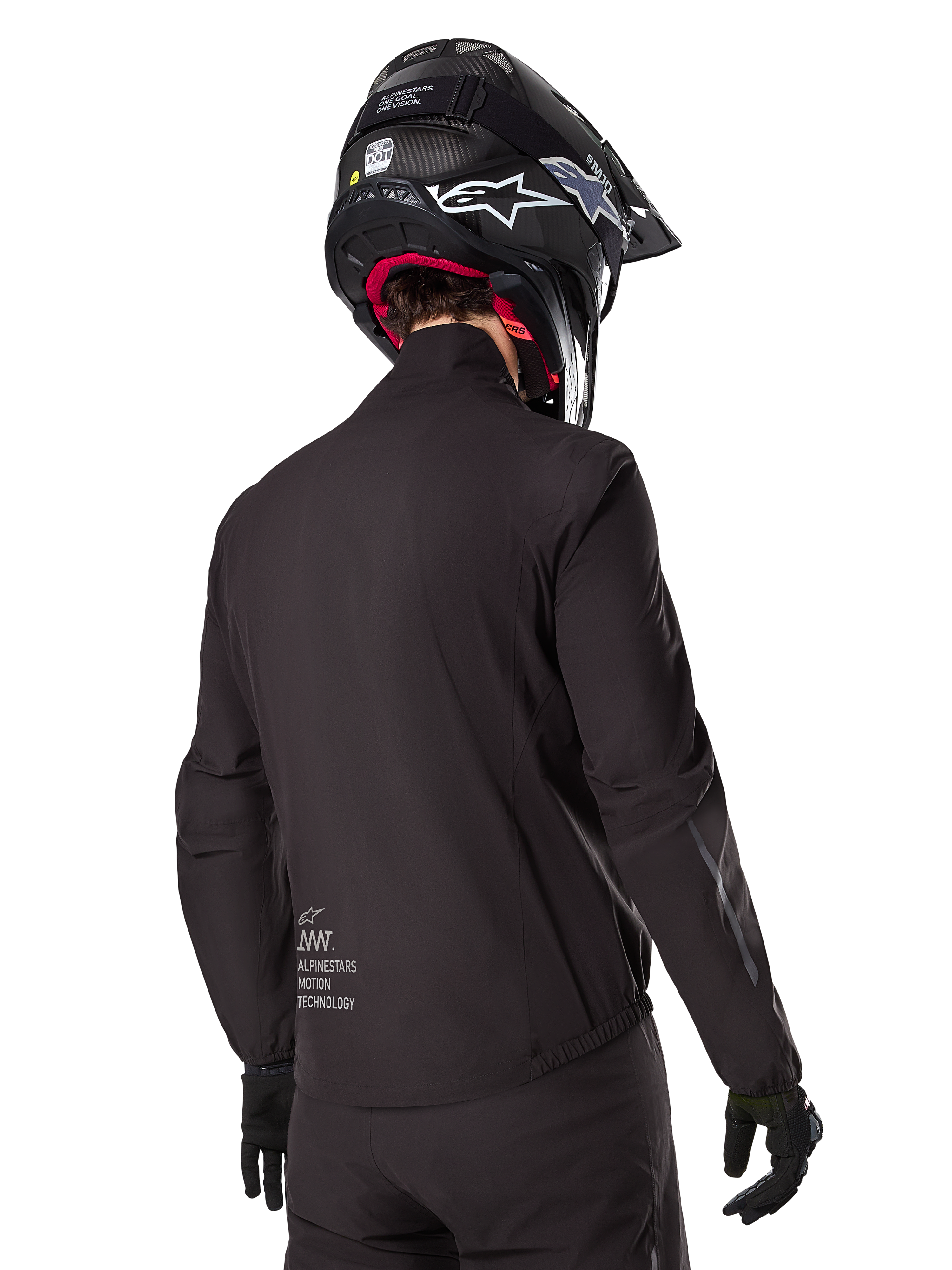 Doublure Alpinestars AMT-8 Stretch Drystar® XF, doublure de veste imperméable noire, vue arrière d'un pilote portant un casque noir et des gants, avec le marquage Alpinestars Motion Technology sur le bas du dos, design minimaliste et fonctionnel pour la conduite aventure.