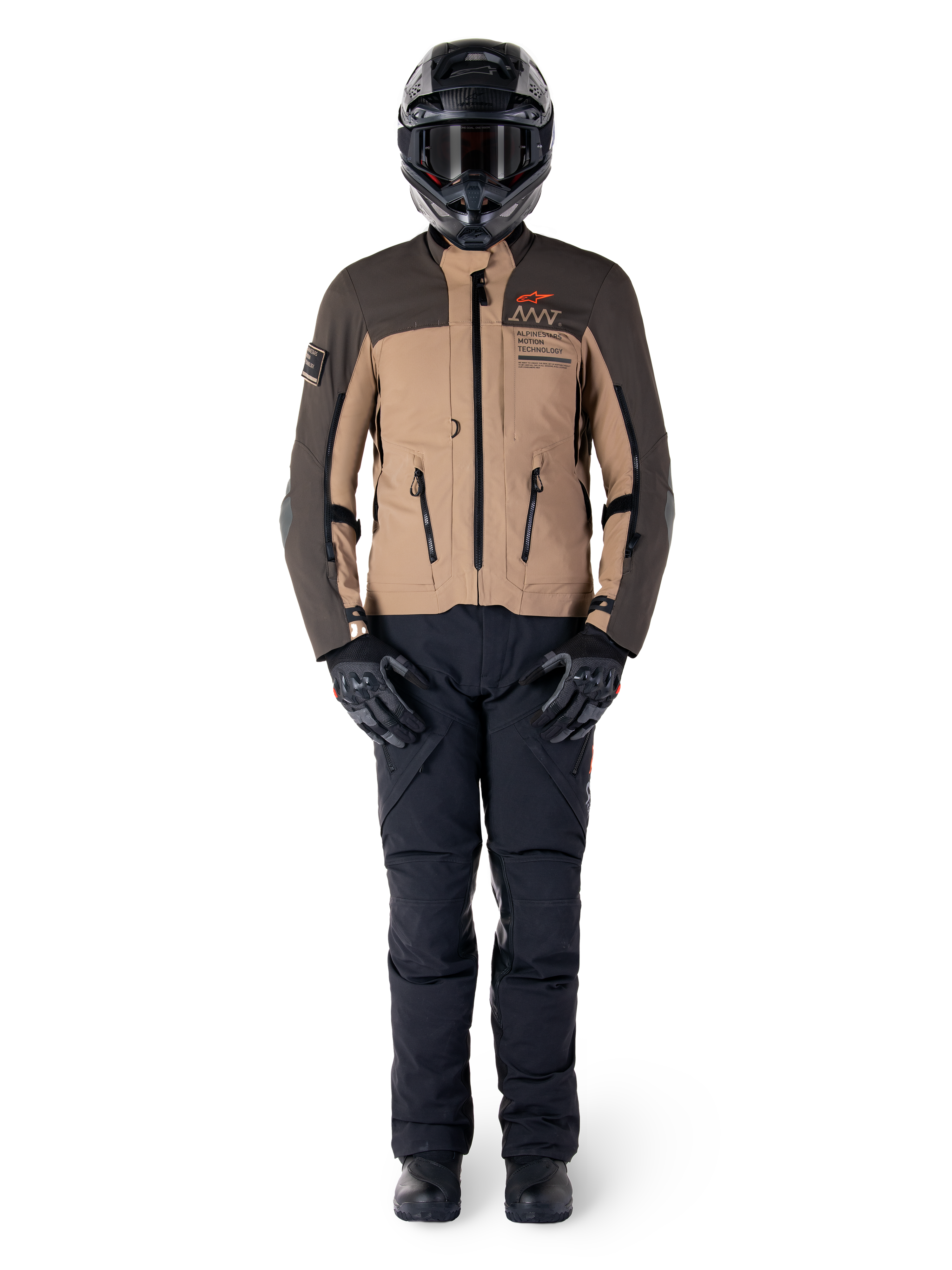 Veste Alpinestars AMT-8 Stretch Drystar® XF, veste de moto adventure, brun foncé et kaki foncé, portée avec un casque noir, un masque, des gants noirs, un pantalon noir et des bottes noires, dotée d'orifices de ventilation sur la poitrine et du marquage AMT, équipement coordonné pour le touring d'aventure