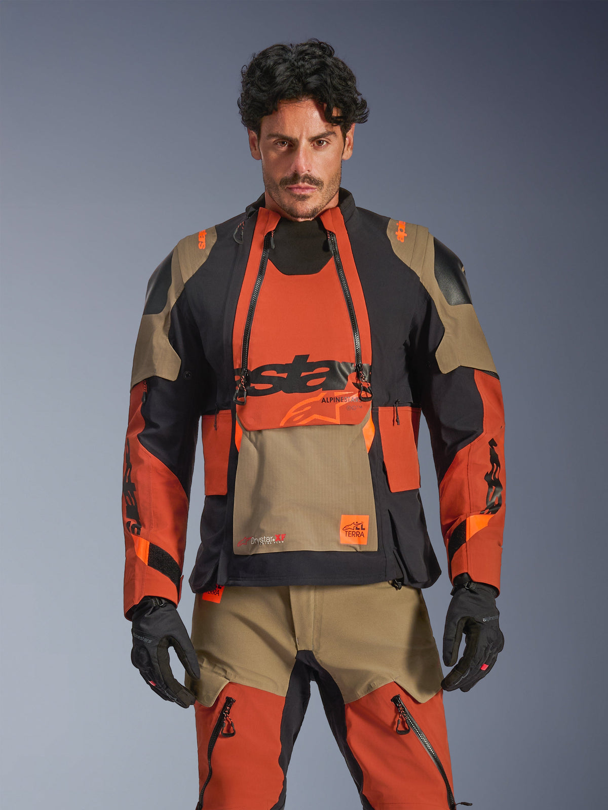 Alpinestars Harok Pro Drystar XF Laminated Jacket, adventure motorcycle touring jacket in walnut rust, black, and tan, worn by a model in a front view featuring waterproof laminated construction and modular ventilation