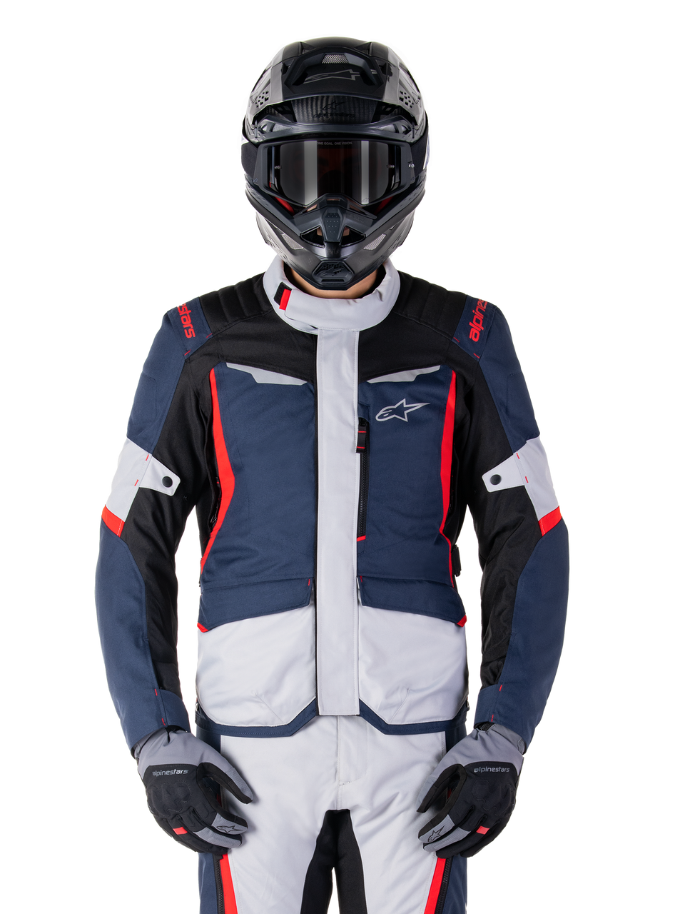 Alpinestars ST-1 Waterproof Jacket, veste de moto imperméable, bleue avec accents rouges et blancs, portée avec casque noir et gants, logo étoile sur la poitrine, design protecteur pour motocyclisme