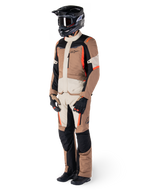 Veste imperméable Alpinestars ST-1, Dark Khaki Sand Black Red Fluo, portée par un pilote en équipement complet de touring aventure avec pantalon assorti, casque noir, lunettes, gants et bottes, tenue de moto technique tout temps