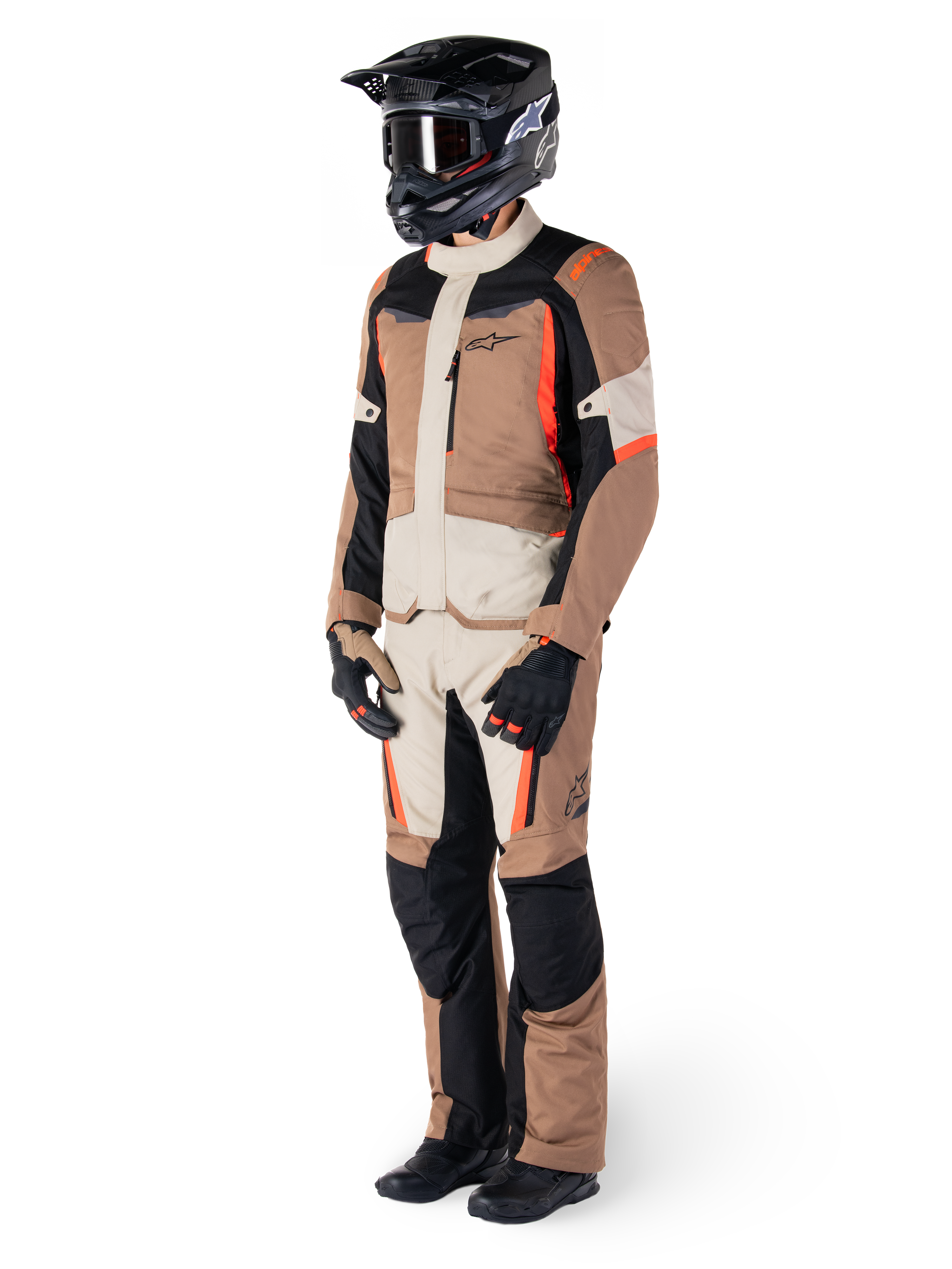 Veste imperméable Alpinestars ST-1, Dark Khaki Sand Black Red Fluo, portée par un pilote en équipement complet de touring aventure avec pantalon assorti, casque noir, lunettes, gants et bottes, tenue de moto technique tout temps