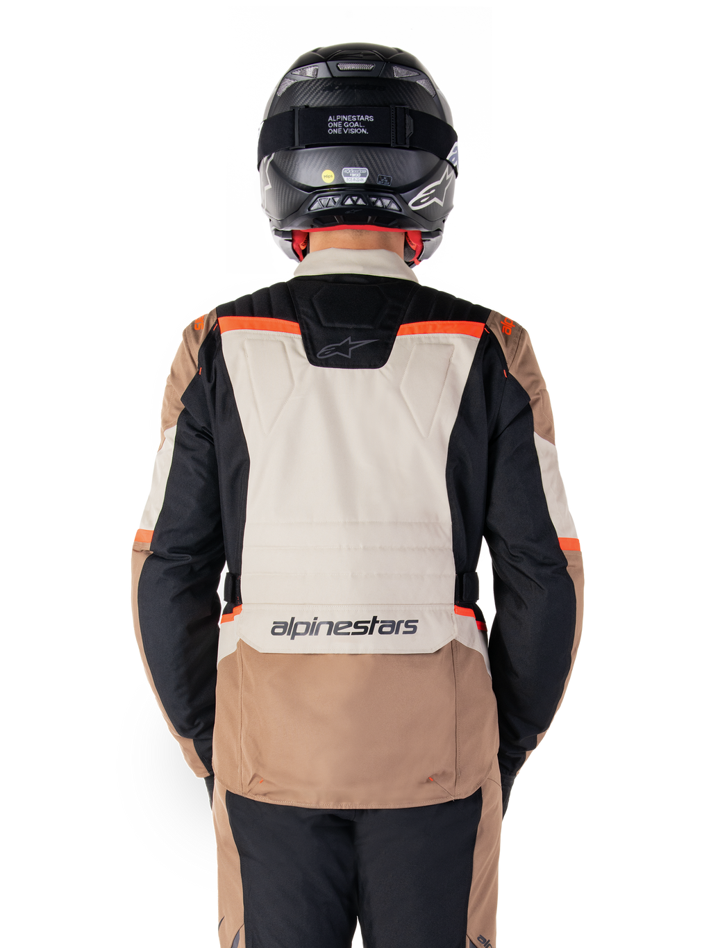 Veste imperméable Alpinestars ST-1, Dark Khaki Sand Black Red Fluo, vue arrière, veste de moto aventure touring dotée d'un large panneau dorsal couleur sable, de manches noires et d'accents rouge fluo, portée par un motard avec un casque noir.