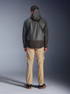 Veste imperméable Alpinestars Mospher WP, parka de moto noire vue de dos, arborant le logo MO.ST.EQ sur le haut du dos et une construction en tissu ripstop, portée avec un pantalon cargo beige et des baskets noires, style urbain.