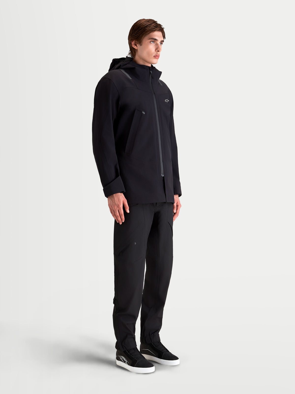 Alpinestars C 7 Drystar Xf Veste, veste de moto urbaine contemporaine en textile pour homme noire, vue de profil latéral portée par un modèle avec construction stratifiée imperméable et capuche intégrée