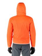 Veste Alpinestars Mohobbs Waterproof, housse de pluie compressible orange fluo vif, vue arrière de la veste légère à capuche, portée avec un pantalon de moto gris foncé et des gants noirs