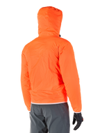 Veste Mohobbs Waterproof d'Alpinestars, doublure de pluie d'urgence compressible de couleur orange fluo éclatant, vue arrière montrant la capuche anti-tempête, portée avec un pantalon de moto gris foncé et des gants noirs, équipement de moto urbain léger et imperméable
