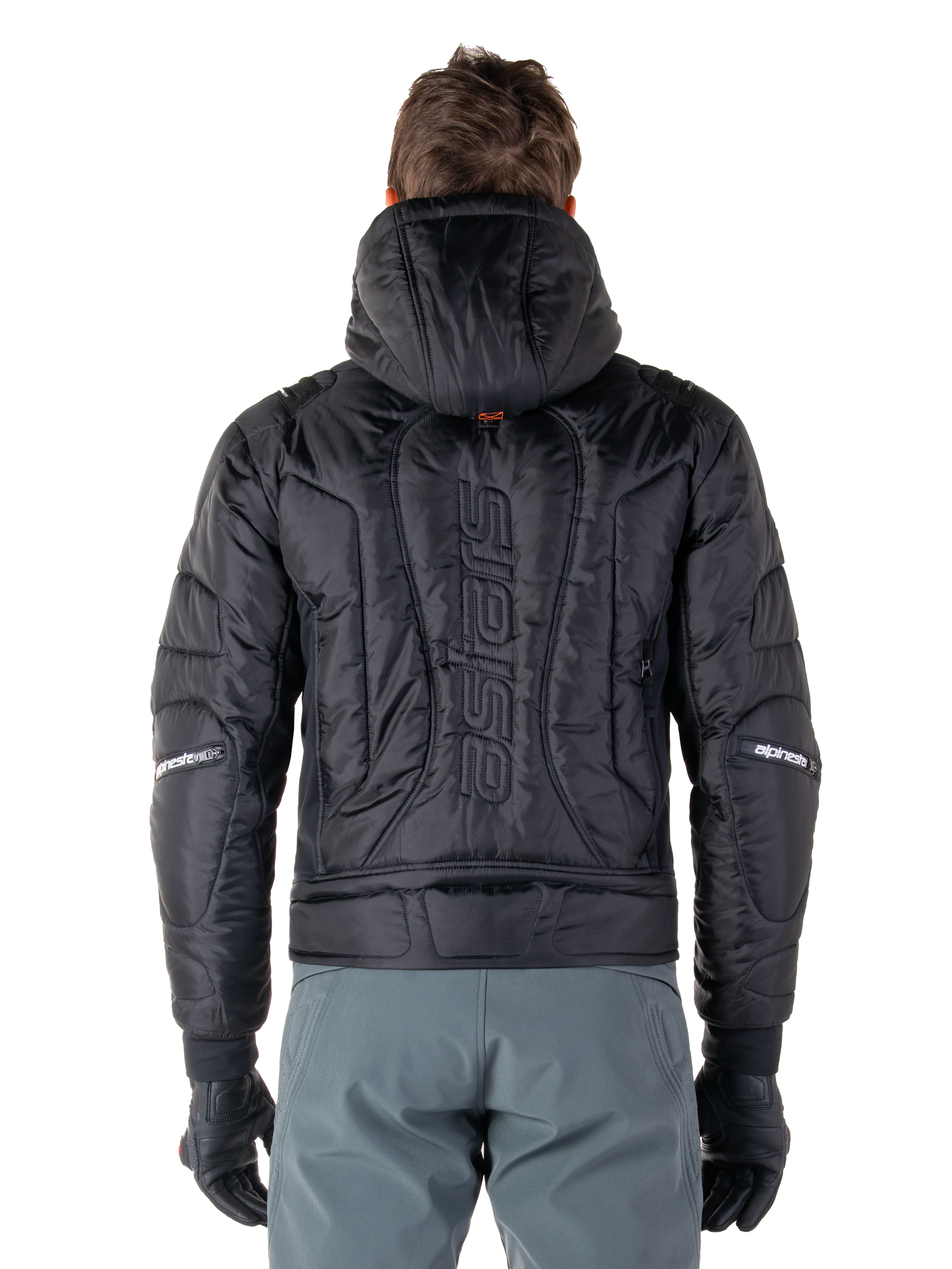 Veste Alpinestars Mohobbs Waterproof, noire, vue de dos montrant la construction matelassée rembourrée, mot-symbole 'astars' vertical au dos, capuche relevée, style moto streetwear contemporain