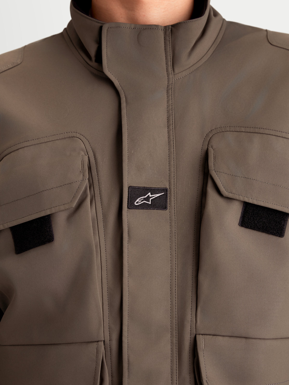 Alpinestars Altan Drystar Veste, veste de moto urbaine contemporaine pour homme en marron marron, vue rapprochée montrant la construction en polycoton mat, les poches cargo à double entrée et le col chaud intégré