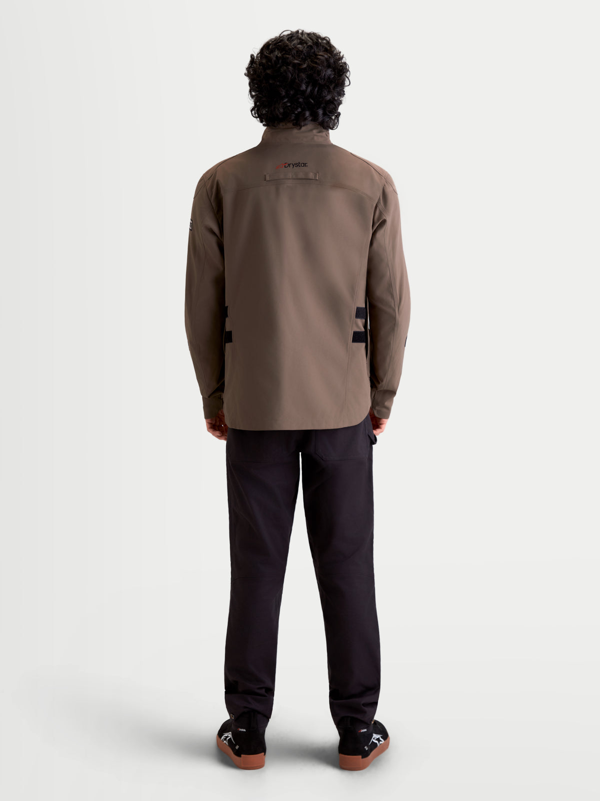 Alpinestars Altan Drystar Veste, veste de moto urbaine contemporaine pour homme en marron et noir, vue de dos sur un modèle montrant la construction de type veste de terrain imperméable et le col haut