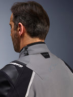 Veste Alpinestars Andes Pro Drystar® XF, gris foncé et noir, gros plan sur le col arrière et le haut de l'épaule, montrant le logo Tech-Air® Ready, le réglage par cordon de serrage et le logo étoile Alpinestars ton sur ton sur le textile technique.