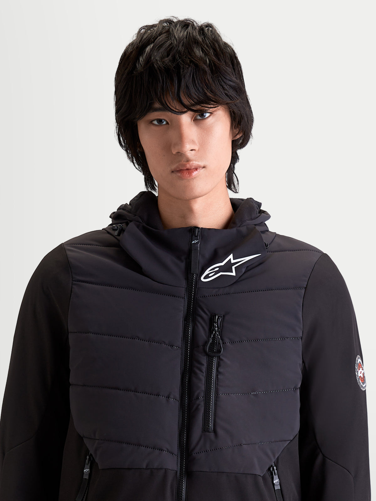 Alpinestars Therma Tech Wp Veste, veste de moto urbaine pour homme noire, vue de face sur un modèle montrant la construction matelassée et le système de capuche intégré