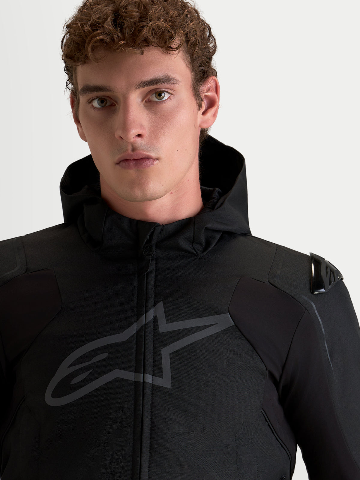 Alpinestars Zaca V2 Waterproof Jacket, Men's Black motorcycle riding jacket featuring DFS shoulder armor and integrated hood, close-up on-model portrait