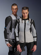 Vestes Alpinestars ST-2 Air et Stella ST-2 Air, gris glacé et noir, vestes de moto en textile avec panneaux en mesh et perforations laser, arborant le marquage « Alpinestars Exploration Equipment », portées par un homme et une femme tenant des gants de moto
