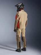 Adventure rider from the back wearing the Alpinestars Maxdura Drystar®XF Laminated Armored Shell in Aluminum Walnut Rust Brown, paired with matching riding pants, black off-road helmet, and black boots, complete technical touring outfit.