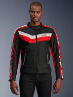 Veste Alpinestars T-Dyno WR, veste de moto en textile, noire avec rayures en chevron rouge vif et écru, coupe biker d'inspiration vintage, col montant avec fermeture à bouton, poches avant zippées, logos étoiles sur les manches, portée par un mannequin
