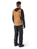 Veste Alpinestars Hyde XT Stretch Drystar®XF et pantalon Hyde XT Drystar®, vue arrière d'un pilote portant un équipement de touring aventure beige et noir, veste dotée de fermetures éclair verticales dans le dos et du marquage Alpinestars, pantalon noir avec logo étoile rouge sur le mollet, associé à des gants et des bottes noirs.