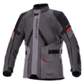 Veste Alpinestars Monteira Drystar XF, veste de moto touring, gris foncé et gris goudron avec empiècements noirs et touches de rouge vif, comprenant des poches cargo à l'avant, des sangles réglables à la taille et aux bras, un logo Alpinestars vertical et un col haut, conçue pour la conduite aventure