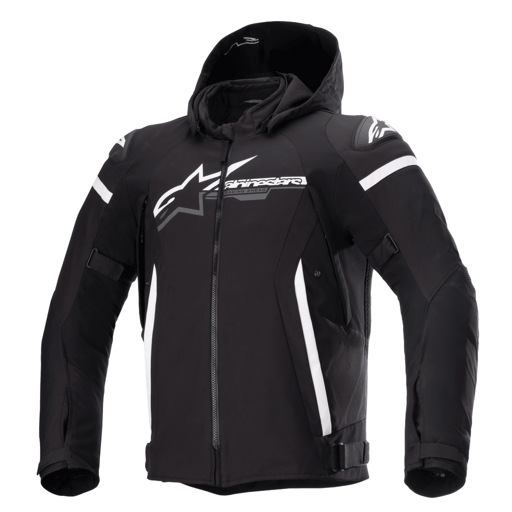 Veste imperméable Alpinestars Zaca, veste de moto noire avec capuche amovible, grand logo Alpinestars blanc sur la poitrine, bandes blanches sur le haut des bras et accents latéraux verticaux, fermeture éclair frontale, rembourrage renforcé aux épaules, sangles de réglage à la taille et aux bras, construction en textile softshell