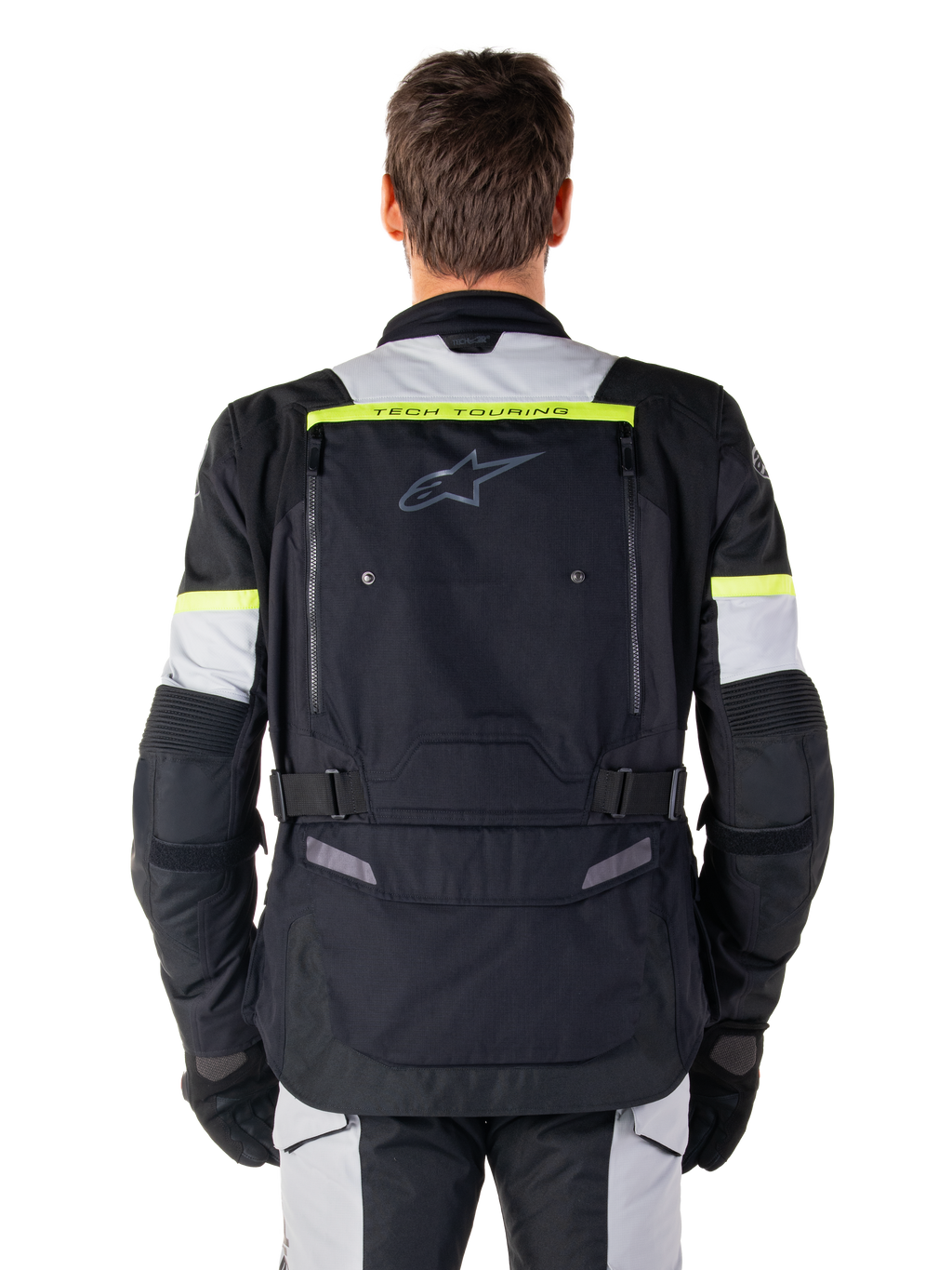 Veste Alpinestars Bogota' Pro Drystar®, veste de moto Adventure Touring, noir, gris glace et jaune fluo, vue arrière montrant le marquage « TECH TOURING » sur une bande jaune fluo, un large panneau de ventilation dorsal et des sangles de réglage à la taille, équipement technique toutes saisons