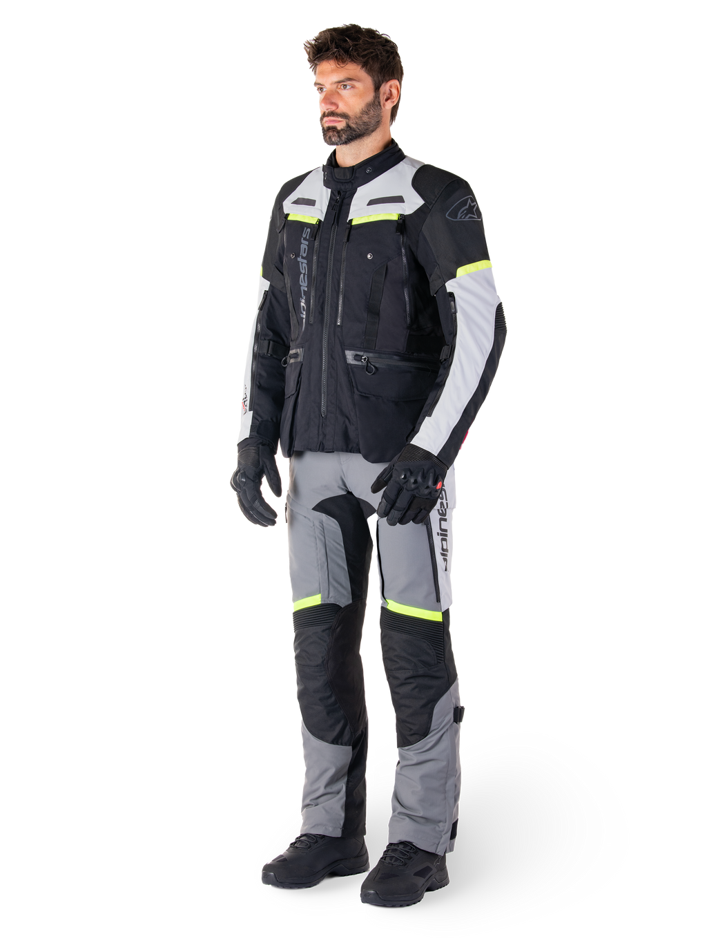 Veste Alpinestars Bogotá Pro Drystar®, veste de moto adventure touring, Black Ice Gray Yellow Fluo, portée par un mannequin avec un pantalon assorti et des gants noirs, dotée d'une construction textile imperméable avec des panneaux de ventilation et des accents fluorescents.
