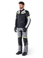 Veste Alpinestars Bogotá Pro Drystar®, veste de moto adventure touring, Black Ice Gray Yellow Fluo, portée par un mannequin avec un pantalon assorti et des gants noirs, dotée d'une construction textile imperméable avec des panneaux de ventilation et des accents fluorescents.