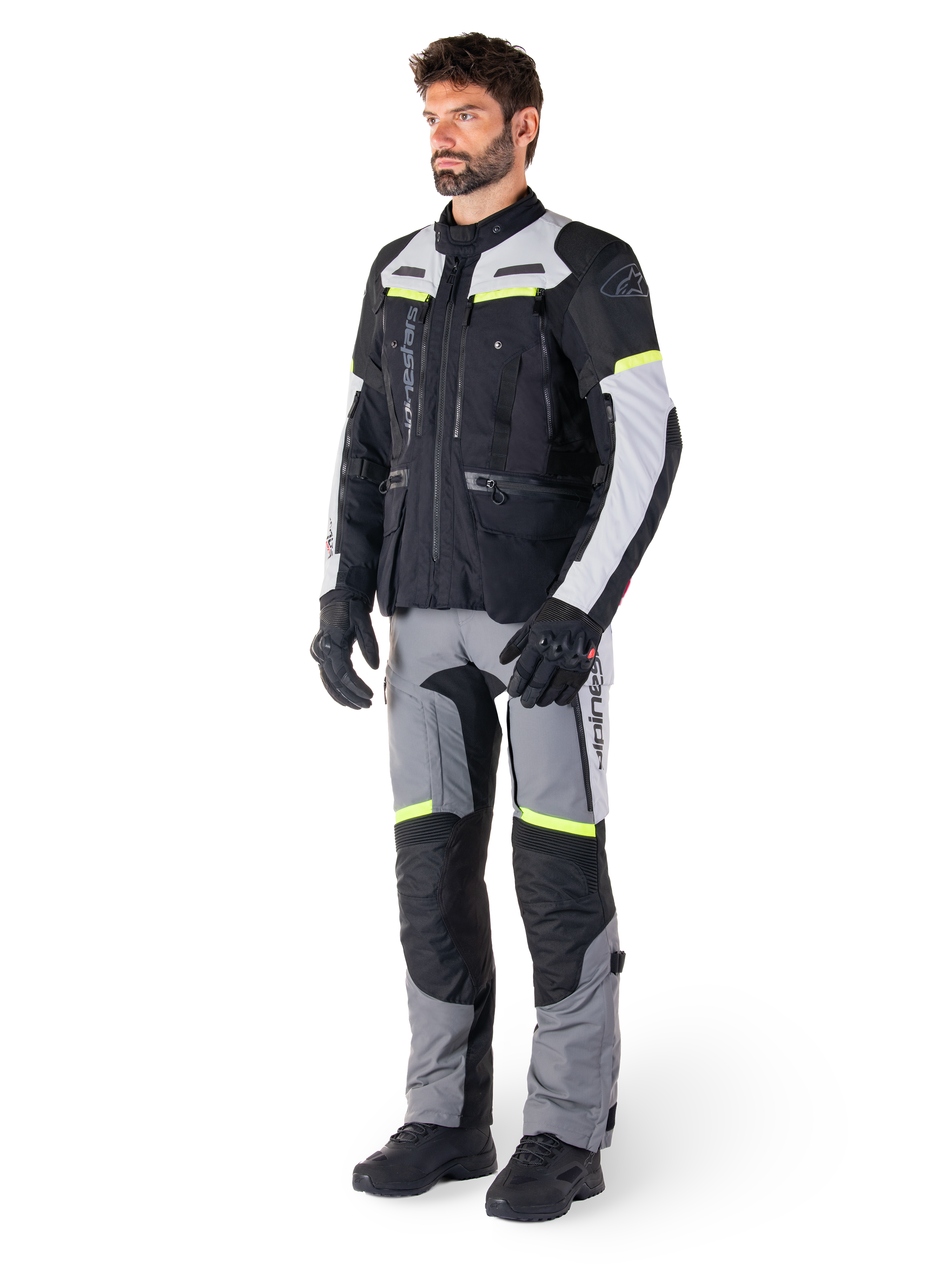 Veste Alpinestars Bogotá Pro Drystar®, veste de moto adventure touring, Black Ice Gray Yellow Fluo, portée par un mannequin avec un pantalon assorti et des gants noirs, dotée d'une construction textile imperméable avec des panneaux de ventilation et des accents fluorescents.