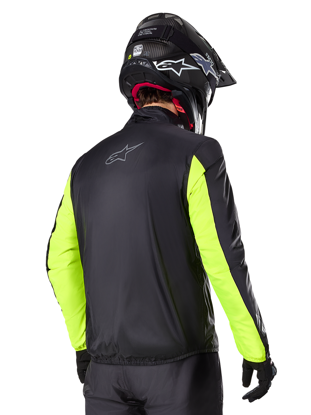 Veste Alpinestars Bogotá Pro Drystar®, vue arrière, noire avec manches jaune fluo, portée par un pilote avec un casque et des gants noirs, équipement de moto d'aventure touring haute visibilité avec une finition en textile technique.