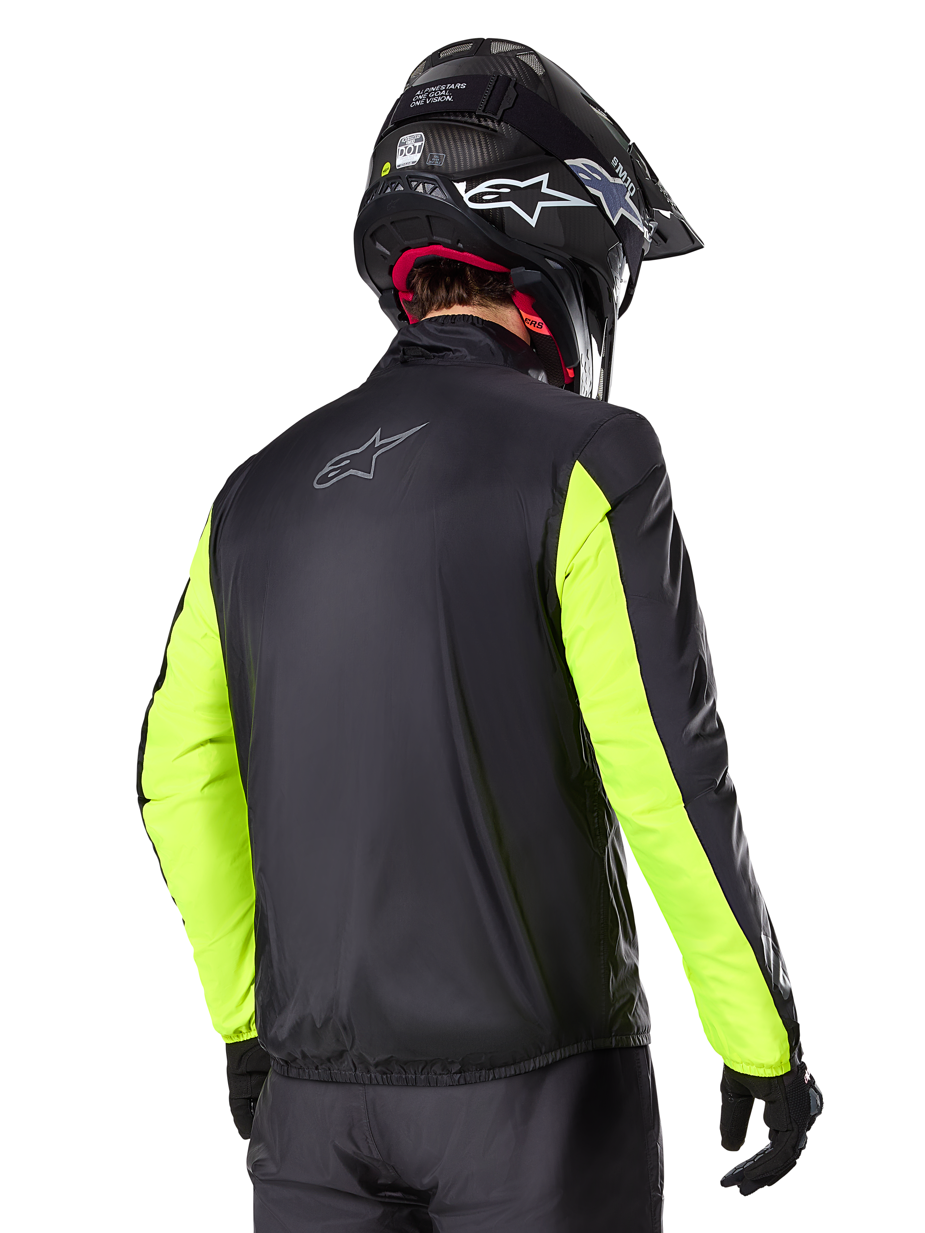 Veste Alpinestars Bogotá Pro Drystar®, vue arrière, noire avec manches jaune fluo, portée par un pilote avec un casque et des gants noirs, équipement de moto d'aventure touring haute visibilité avec une finition en textile technique.