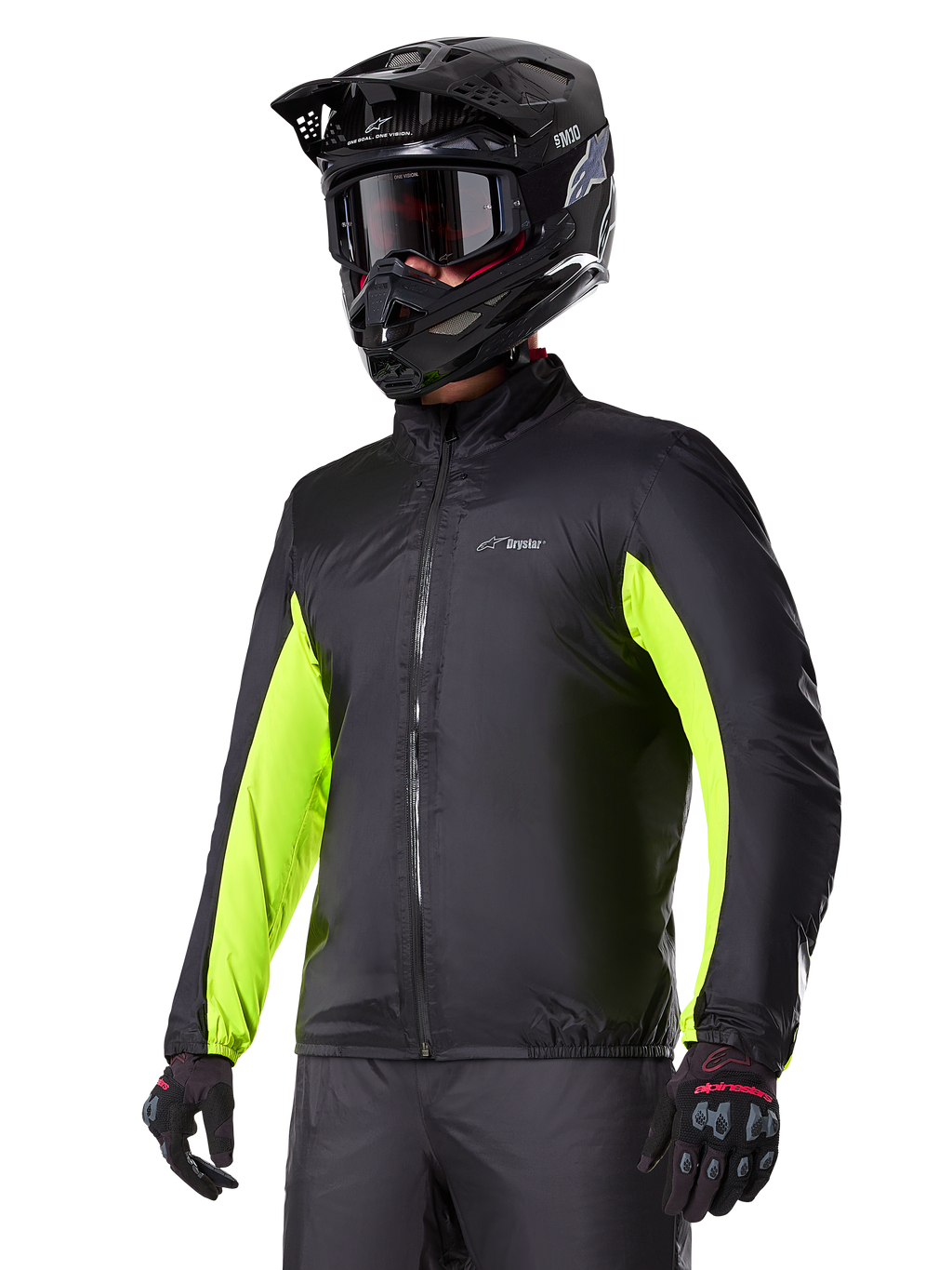 Doublure imperméable Alpinestars Bogotá Pro Drystar®, noire avec des accents jaune fluo éclatants sur les manches, portée par un pilote avec un casque et un masque noirs, équipement de moto technique.