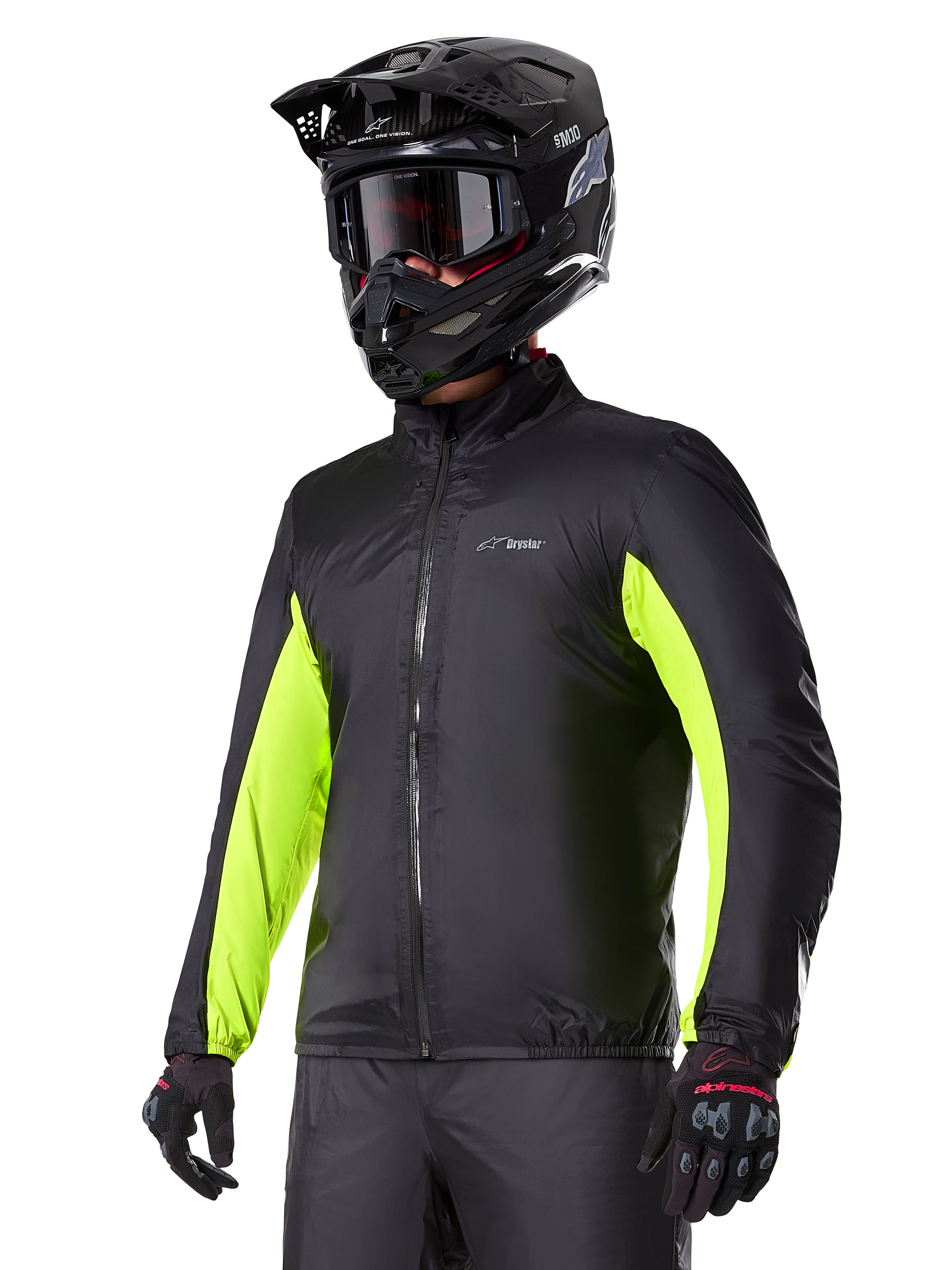Doublure imperméable Alpinestars Bogotá Pro Drystar®, noire avec des accents jaune fluo éclatants sur les manches, portée par un pilote avec un casque et un masque noirs, équipement de moto technique.