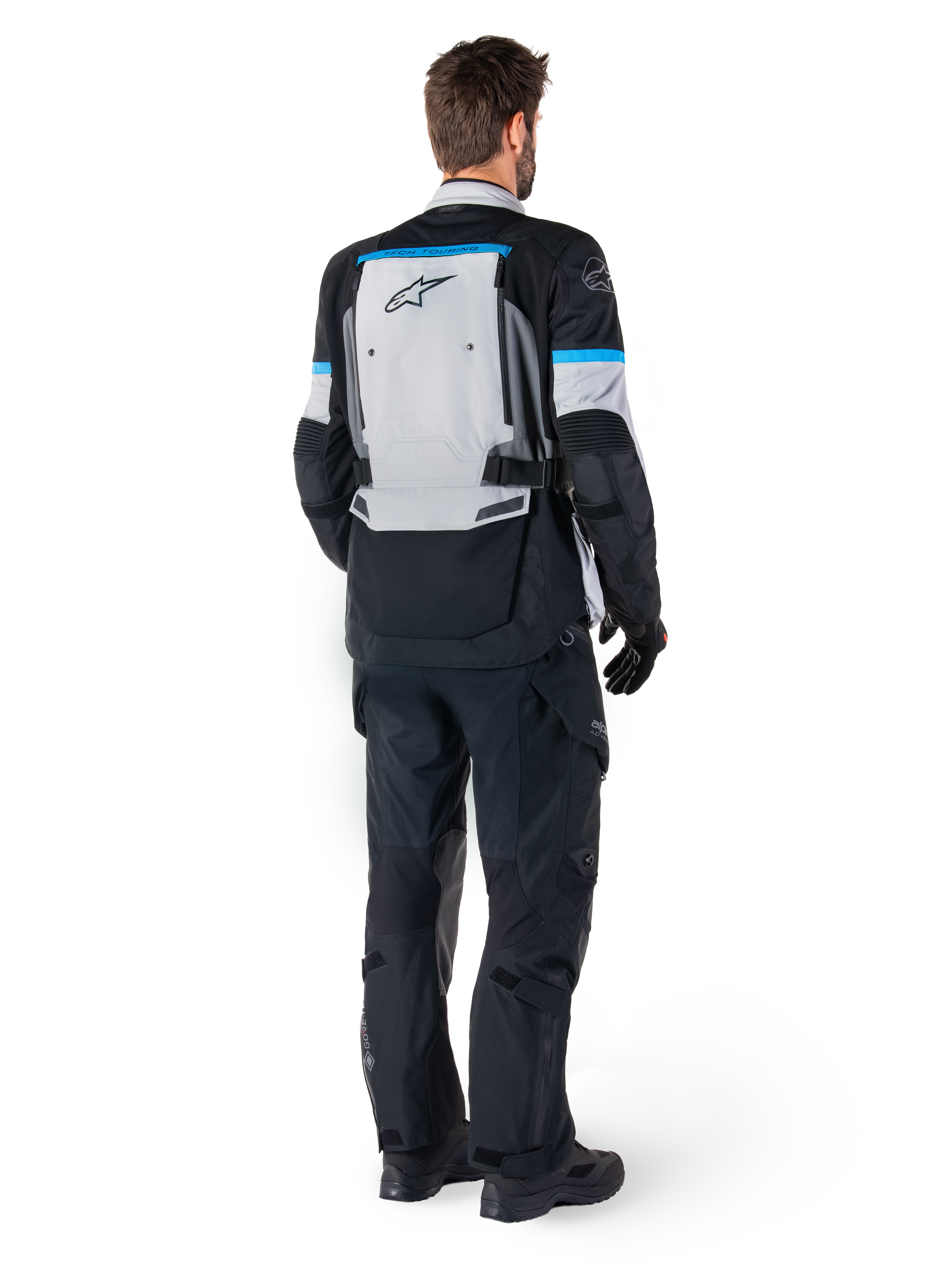 Alpinestars Bogota' Pro Drystar® Jacket, Adventure Motorcycle Jacket, Ice Gray Black and Cyan, rear view worn with matching black pants and gloves, featuring a large gray back panel with black Alpinestars logo and cyan blue accents.